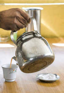 Image of a man pouring chai into a cup