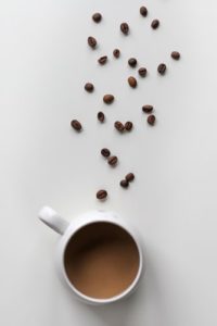 coco beans spilled on a table with a cup