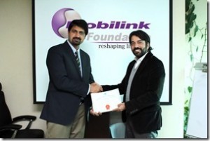 Malik Babur Javed, Program Manager Certification, PCP (L) presenting the PCP Certification to Omar Manzur, Head of Corporate Communications, Mobilink.