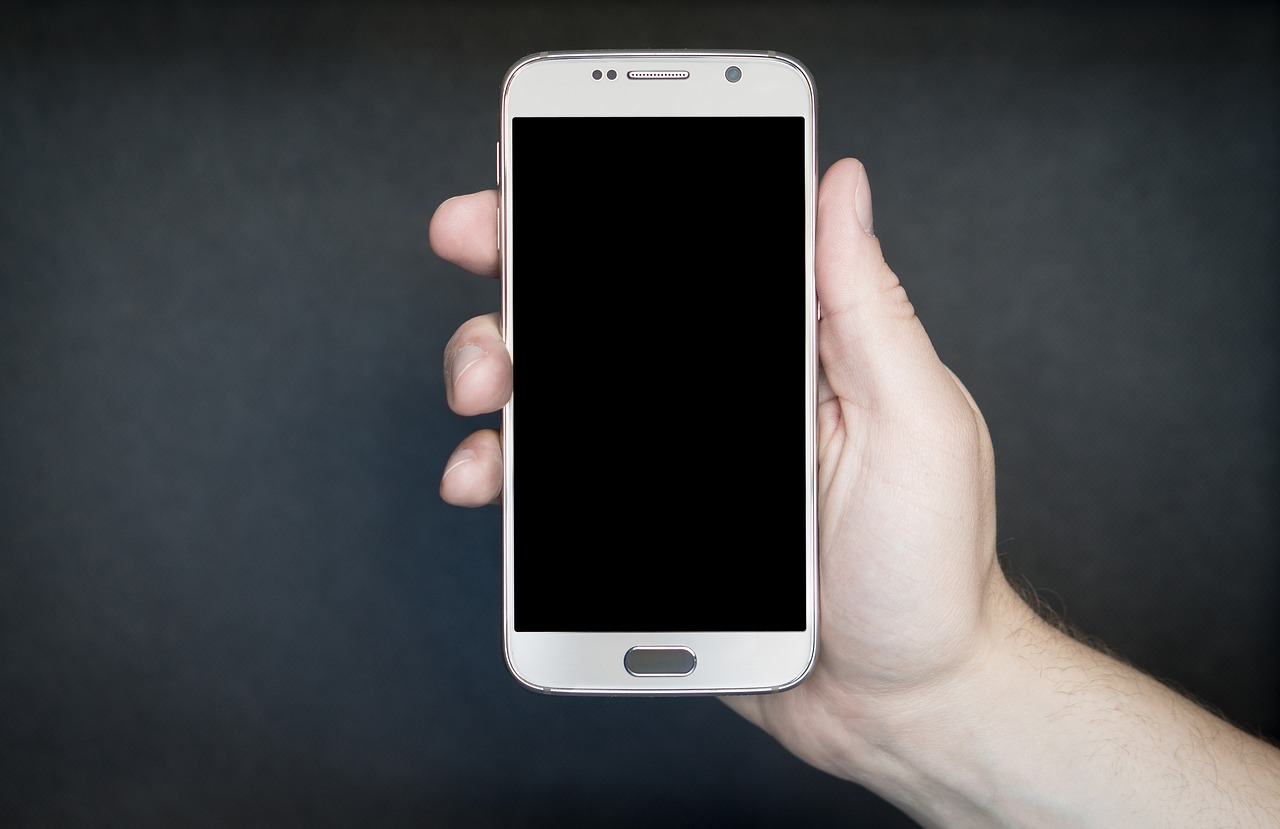 white smartphone in hand