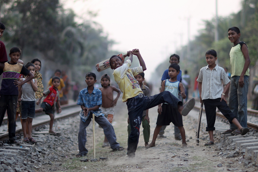 Children play cricket on the railway tracks in Bangladesh