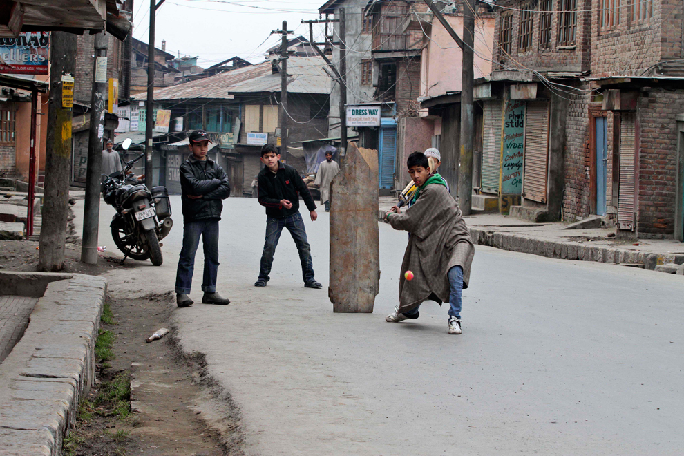 Kashmiri boys playing cricket on road in Srinagar